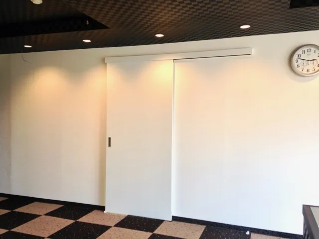 間仕切り壁にドアを付けて部屋の用途を変える工事